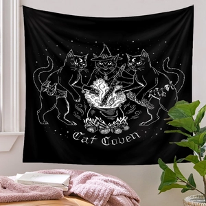 Detail of black Cat Coven tapestry featuring white line art of cats and witch cauldron