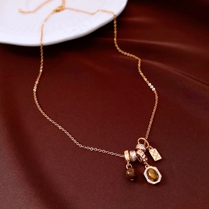 Detailed shot of tiger eye bead pendant necklace on dark brown silk background