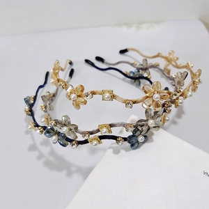 Makro-Detail des Kristall-Blumen-Haarreifs mit Gold-Finish und funkelnden Kunstperlen