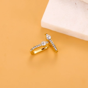 Detailed close-up of gold titanium earrings with central round zircon and small stones