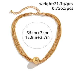 Detail view of multi-layered gold chain necklace with smooth metal ball pendant