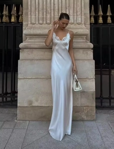 Outdoor shot of white satin slip maxi dress with elegant lace patchwork and v-neckline