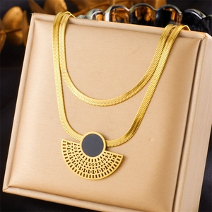 Detail of double-layer gold snake chain necklace with black fan-shaped pendant