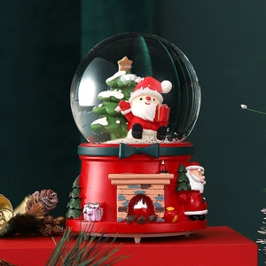 Detailed close-up of a Santa Claus crystal ball music box with a festive fireplace base