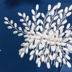 Handmade bridal hair comb with elegant white pearls on a gold metal frame for weddings