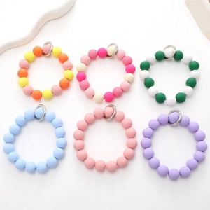 Detailed view of six colorful silicone beaded keychain bracelets with silver rings