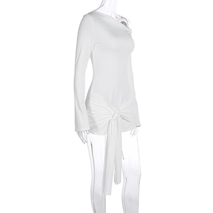 Détail d'une robe blanche à une épaule avec nœud élégant à la taille et rubans décoratifs