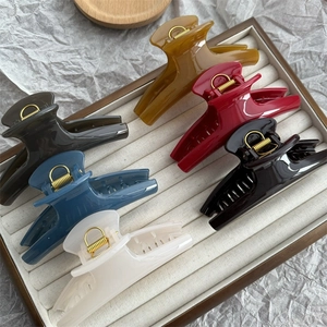 Set of six colorful 11cm curved shark hair clips in a wooden tray with velvet lining