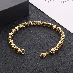 Détail d'un bracelet byzantin doré avec fermoir mousqueton sur un fond noir texturé élégant