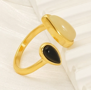 Détail d'une bague ouverte plaquée or 18 carats avec pierres crème et noire en forme de goutte