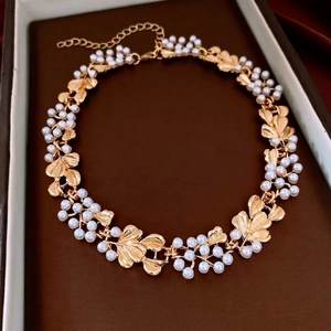 Vintage style gold flower necklace with white pearls displayed in a luxury jewelry box
