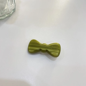 Detailed top view of a green jelly bow hair clip with engraved handmade lettering