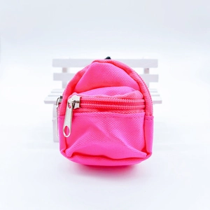 Macro detail of a mini neon pink backpack coin purse with silver zipper on white seat
