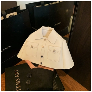 Close-up of creative cream white jacket shaped shoulder bag with metal chain strap