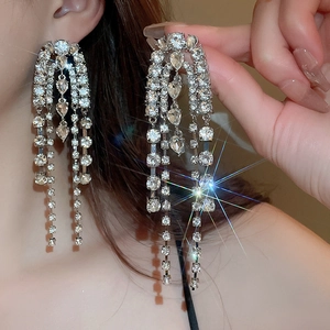 Detail of silver drop tassel earrings with sparkling rhinestones on an elegant model