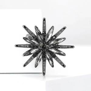 Macro detail of starburst brooch with dark grey metal and black rhinestone inlay