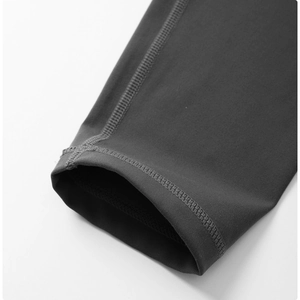 Detail of high-waist yoga pants featuring durable flatlock stitching in dark grey fabric