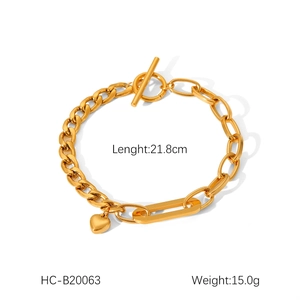 Detail of 18K gold-plated stainless steel Cuban link bracelet with heart charm and OT buckle