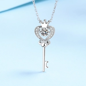 Dettaglio del ciondolo a chiave in argento con corona e cuore e diamante incastonato al centro