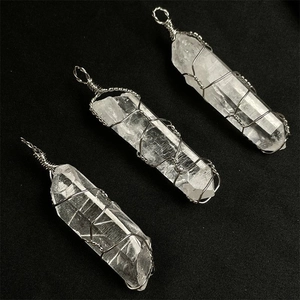 Detailed macro view of three natural white crystal pendants with silver wire wrapping