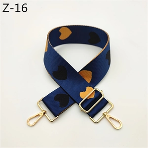 Dettaglio tracolla regolabile in nylon blu con motivo a cuori gialli e ganci in metallo oro