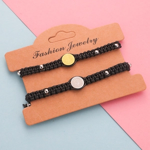 Detail of woven wax rope bracelets with metallic Saint Benedict medals and silver beads
