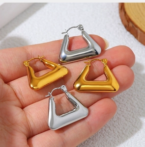 Detailed view of polished geometric triangle earrings in gold and silver finishes