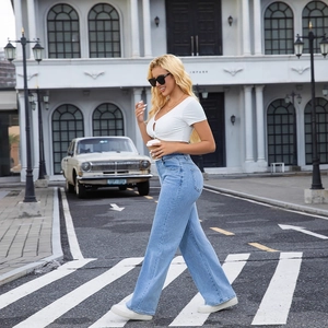 Jean taille haute à jambes larges pour femme avec crop top blanc dans un décor urbain