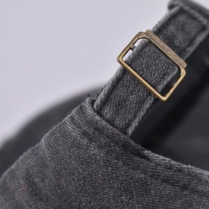 Detailed macro of vintage bronze metal buckle and adjustable strap on charcoal baseball cap
