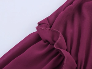 Gros plan sur le tissu mousseline violet foncé montrant les bords volantés et l'ourlet