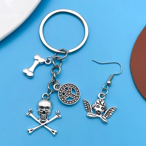 Detail of tibetan silver key ring with skull bone charms and winged angel earring charm