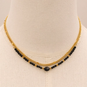 Detailed view of double-layer stainless steel necklace with black beads and oval stone