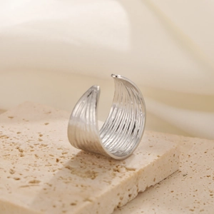 Macro shot of wide silver stainless steel ring with vertical textured stripes on stone
