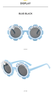 Detailed view of blue flower-shaped kids sunglasses with pearls and Happy Birthday text