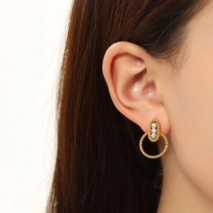 Close-up of a gold-plated twist rope earring with crystals worn by a model
