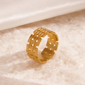 Minimalist adjustable golden woven textured stainless steel ring on a white display pedestal