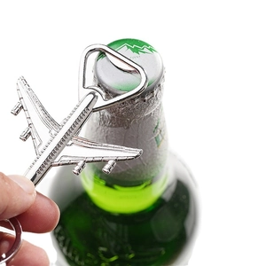 Silver airplane bottle opener keychain made of polished metal shown with a beer bottle