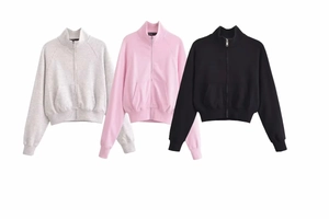 Flat lay of cotton tracksuits in grey pink and black with zip-up collars and flared pants