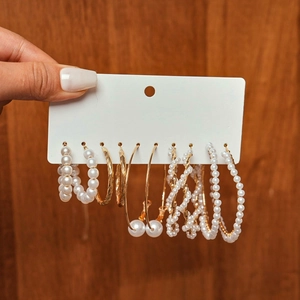 Detail of 10-piece gold earring set with faux pearls and twisted hoops on a display card
