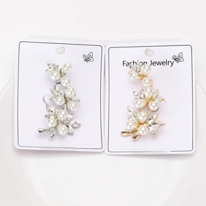 Macro detail of elegant silver and gold flower brooches with pearls and crystals