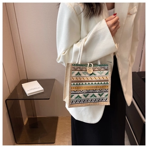 Détail du sac en lin avec rayures géométriques et poignées en coton blanc tressé