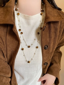 Collier double rang avec œil de tigre et perles porté par un mannequin en tons terre