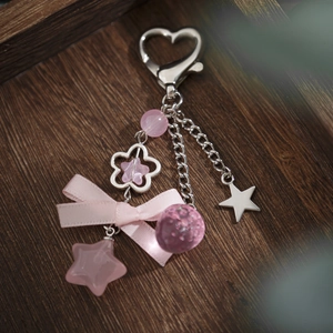 Pink heart keychain with beads, bow, flower, and star pendants on silver chain
