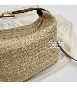 Dettaglio della trama intrecciata beige con manico in pelle marrone e fibbia dorata