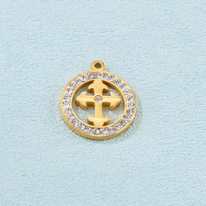Gros plan du pendentif doré rond avec croix évidée et incrustations de cristaux brillants