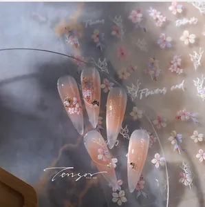 Detail van nagelstickers met roze bloemen, witte vlinders en parelmoer accenten