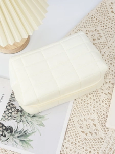 Close-up of beige quilted velvet makeup bag showing soft texture and diamond pattern