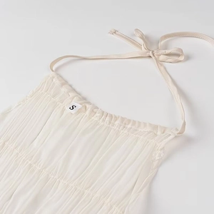 Dettaglio del top bianco a fascia con scollo all'americana, trama a pieghe e taglia S