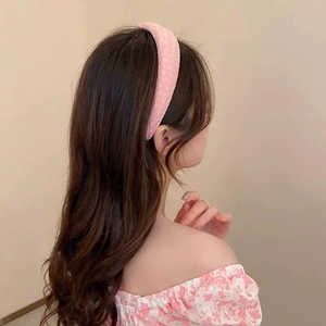Dettaglio del cerchietto imbottito rosa che mostra il tessuto spesso testurizzato sulla modella