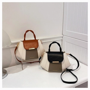 Detail of two-tone crossbody bags in white, brown, and black with gold hardware accents